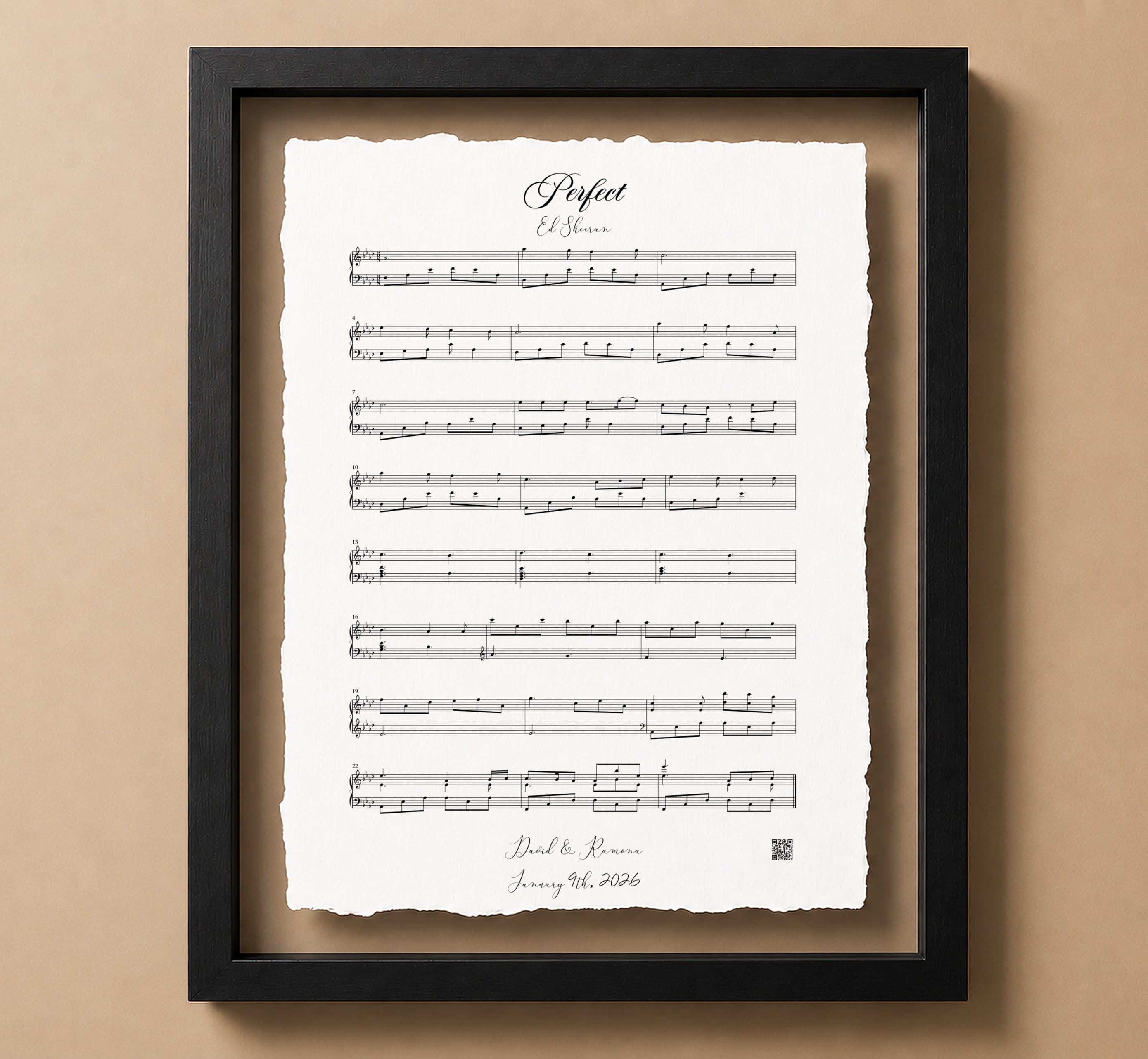 A framed piano arrangement print with visible sheet music notation, displayed in a black float frame against a warm tan background.